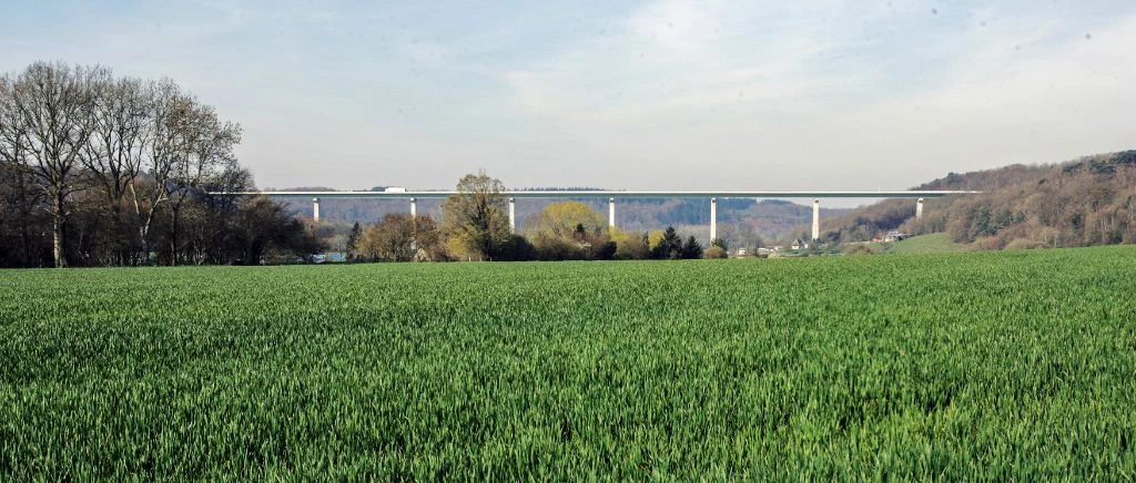 Viaduc blanc au loin avec champ de blé au premier plan
